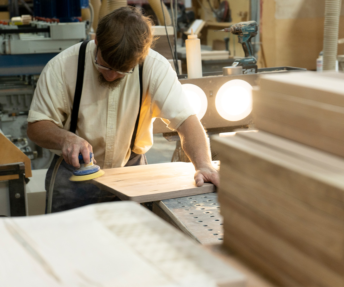 Craftsperson measuring solid wood during furniture construction