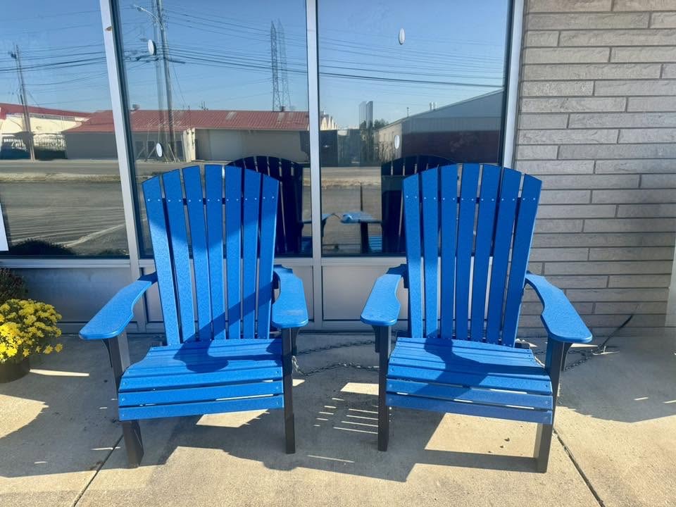 Two bright blue poly Adirondack chairs displayed outside Perry's showroom.